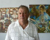 Олександр Демиденко на фоні власних картин